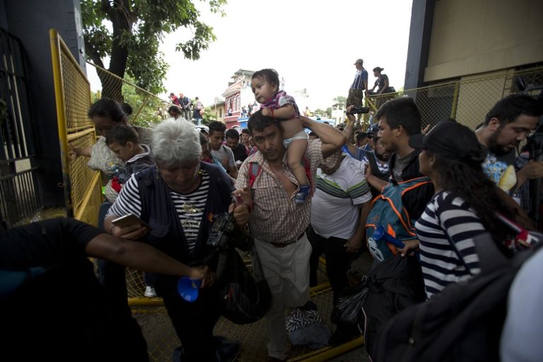 Caravana migrante intenta cruzar puente hacia México